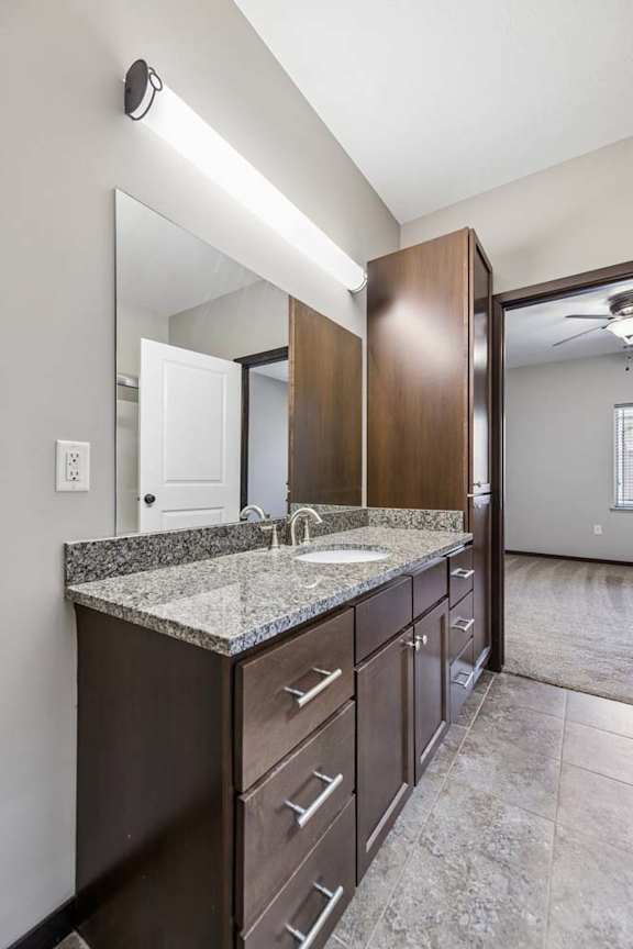 A bathroom with a sink, mirror, and cabinets.