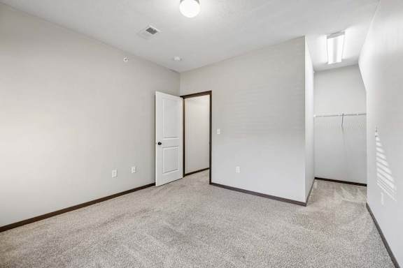 A room with a carpeted floor and a white door.