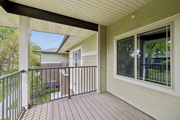 A balcony with a black railing and a window.