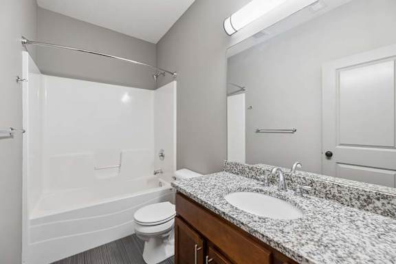 A bathroom with a toilet, sink, and shower.