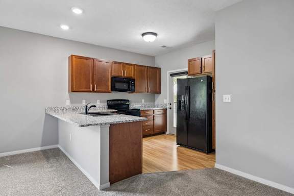 A kitchen with a granite countertop and wooden cabinets.