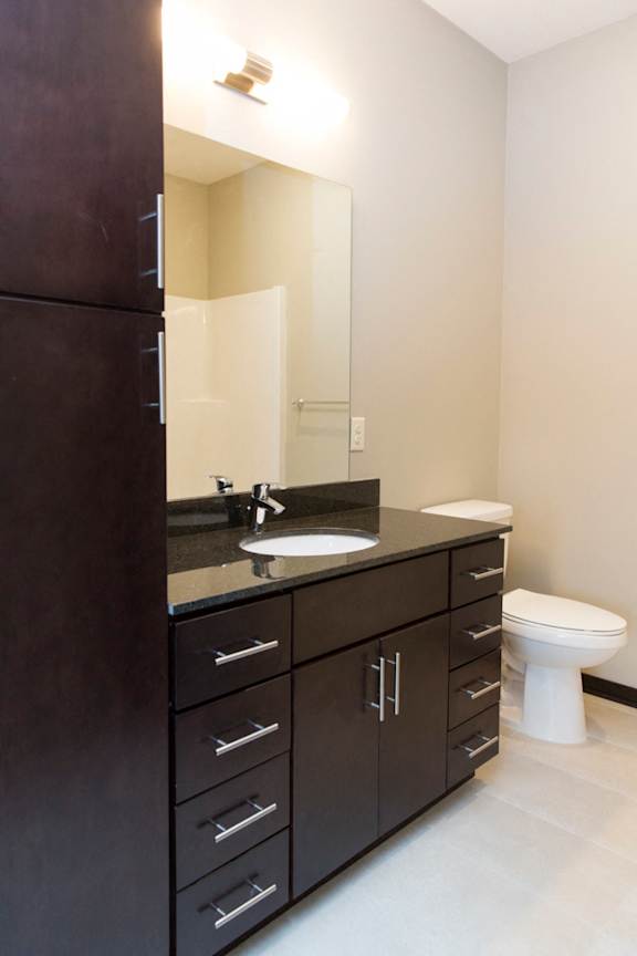 A bathroom with a sink, mirror, and toilet.