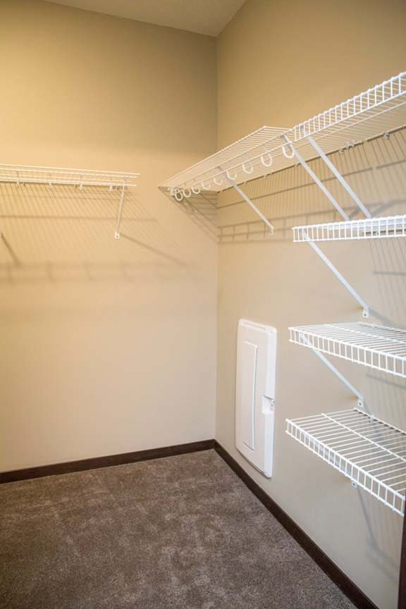 Empty white shelves in a room with a door.