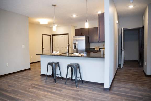A kitchen with a bar stool and a counter.