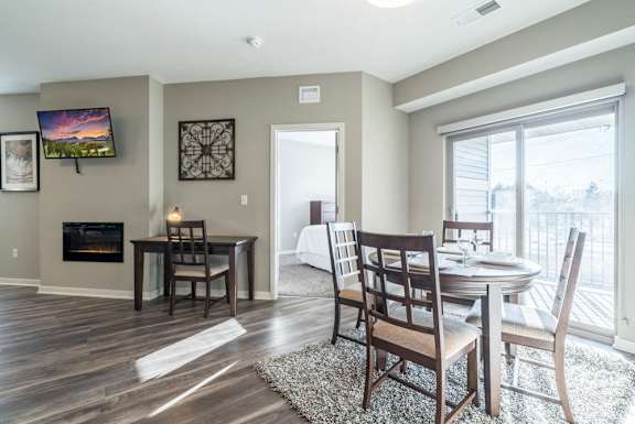 A dining room with a fireplace and a television mounted on the wall.
