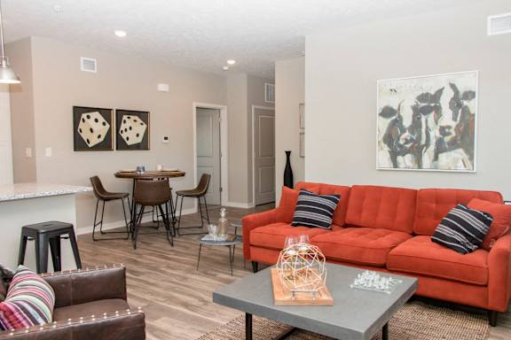 A living room with a red couch and a grey coffee table.