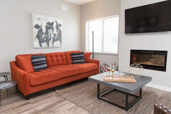 A living room with a red couch and a grey coffee table.