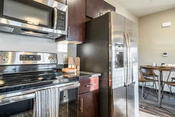 Kitchen with stainless steel appliances and a side by side refrigerator at The Villas at Mahoney Park