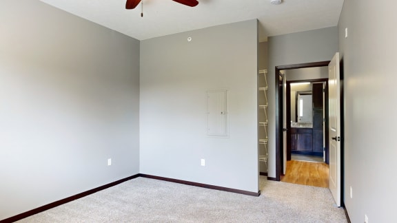 a bedroom with a walk-in closet and ceiling fan