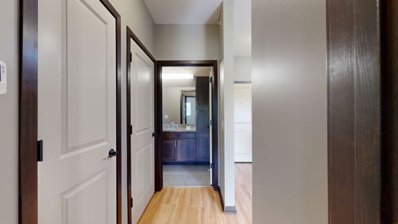 a hallways with doors to the bathroom, laundry room, and closet