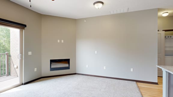a carpeted living room with an electric fireplace