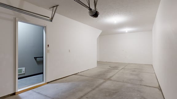 spacious tandem garage with a white walls and concrete floor