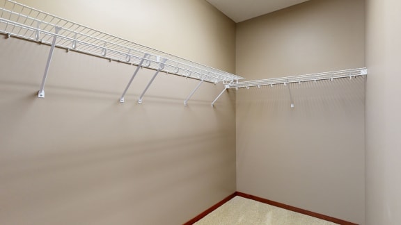 a large walk in closet with wire shelving