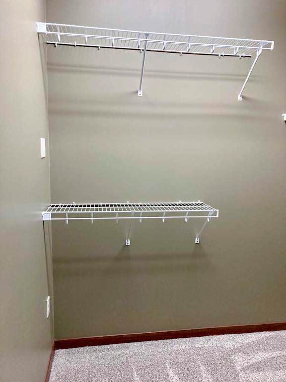 A walk-in closet with built-in wire shelving and hanging space.