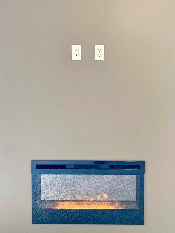 An electric fireplace with a realistic flame, and two outlets to mount a tv above.