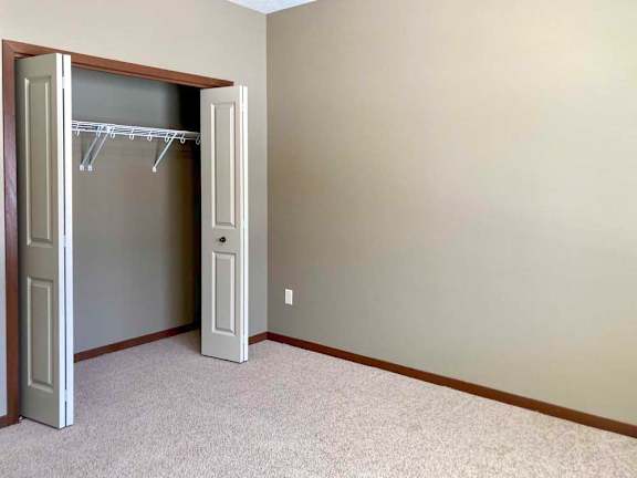 A bedroom with a sliding door closet.
