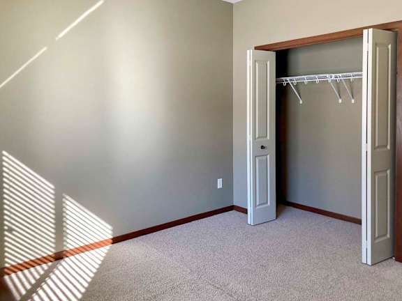A room with a grey wall and a white door with a white frame.