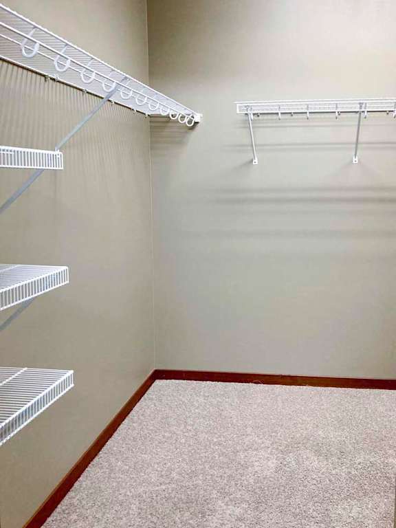 A spacious walk-in closet with wire shelving and hanging space.