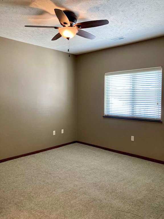 A bedroom with a ceiling fan and a window with blinds.