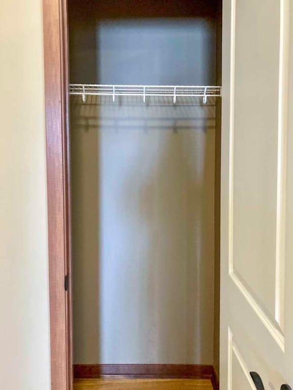 A hallway coat closet with a shelf.