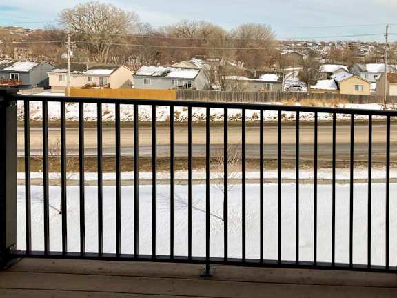 A view from a balcony overlooking a neighborhood across a street.