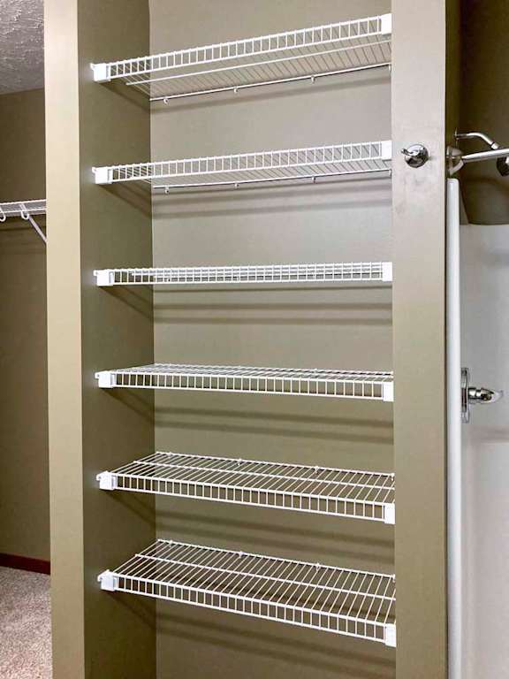 A stack of built-in wire shelves for bathroom linens.