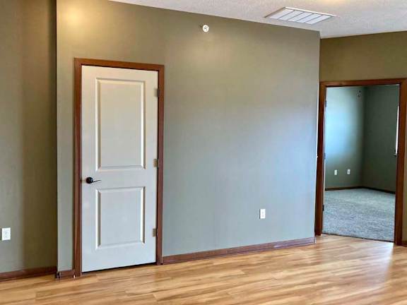 A dining area next to the front entryway closet with hardwood-style flooring.