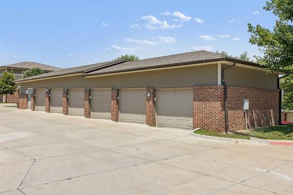 Detached garage building at Villas of Omaha at Butler Ridge with multiple individual garage doors and brick exterior.