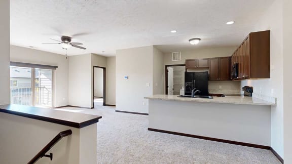 an open-concept kitchen and living room at the top of a staircase
