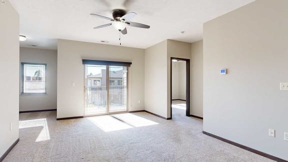 a living room with a sliding glass door to a patio and an adjacent den space