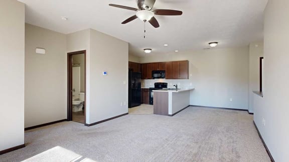 an open-concept living room and dining are next to an L-shape kitchen