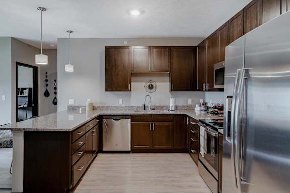 A modern kitchen with dark wood cabinets and stainless steel appliances
