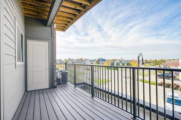 a balcony with a door to an outdoor stage closet and a view of the city
