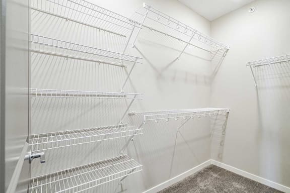 a walk-in closet with built in wire shelving