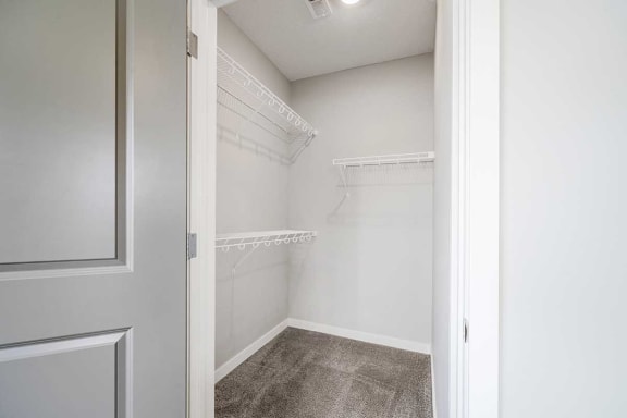 a walk-in closet for the second bedroom with built-in shelves