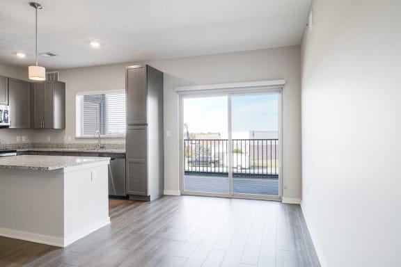 an open kitchen and dining room with a door to a balcony