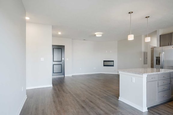 an open-concept living room and kitchen area with hard wood flooring and a fireplace