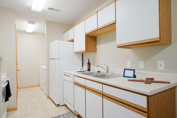 Traditional kitchen with white cabinets, a dishwasher, a sink and a refrigerator