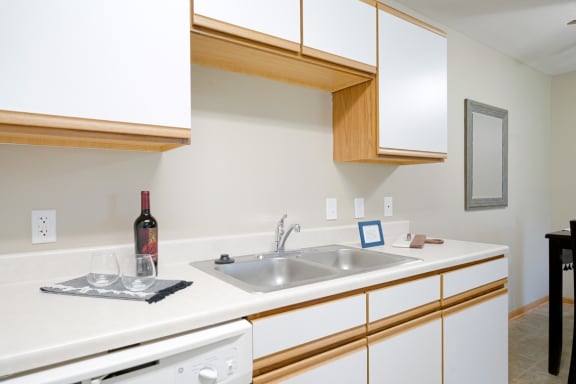 a kitchen with a sink and a bottle of wine on the counter