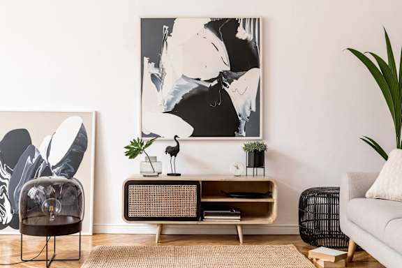 A living room with a large painting on the wall and a chair in front of it.