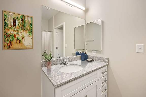 A bathroom with a sink, mirror, and a painting on the wall.