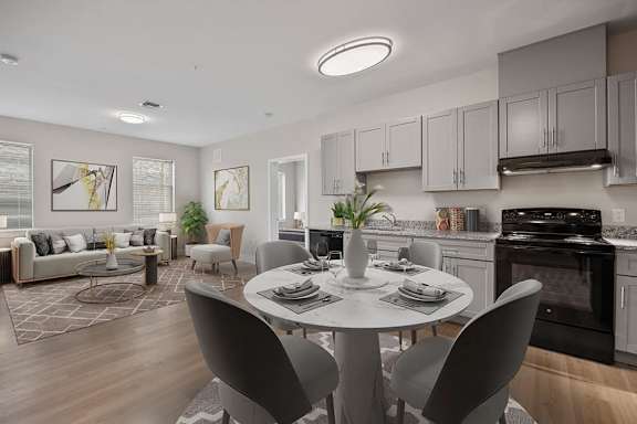 A modern kitchen with a dining table set for two.