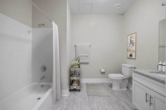 A bathroom with a white tub, toilet, and sink.