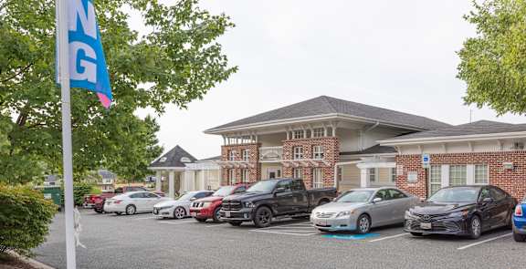 A parking lot with cars and a building in the background.