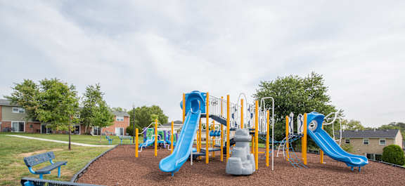 A playground with a blue and yellow slide.
