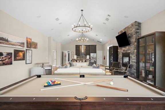 a living room with a pool table and a fireplace