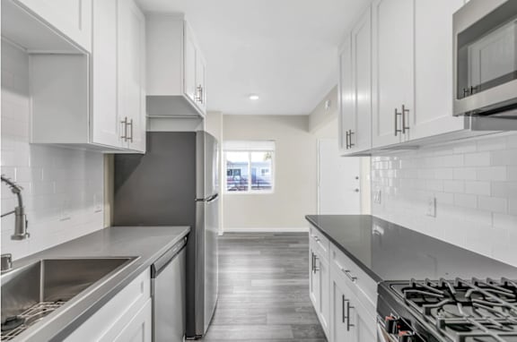 A modern kitchen with stainless steel appliances and white cabinets.