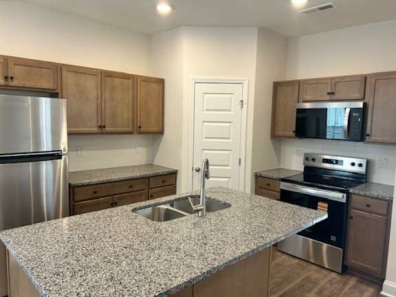 A kitchen with granite countertops and stainless steel appliances.