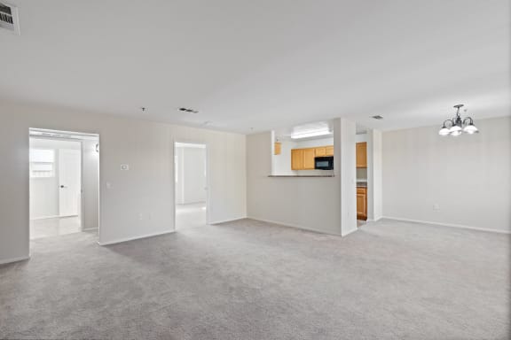 the spacious living room and kitchen in a new home