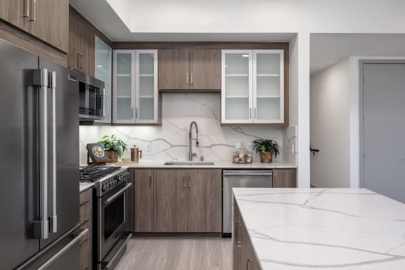 a kitchen with stainless steel appliances and marble counter tops
